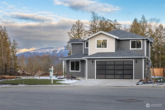 front of property with a garage and a mountain view