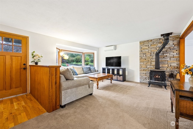 carpeted living room with a wall unit AC and a wood stove