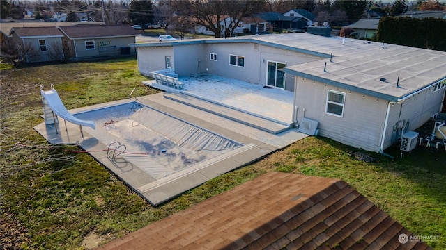 back of property with ac unit, a patio, and a yard