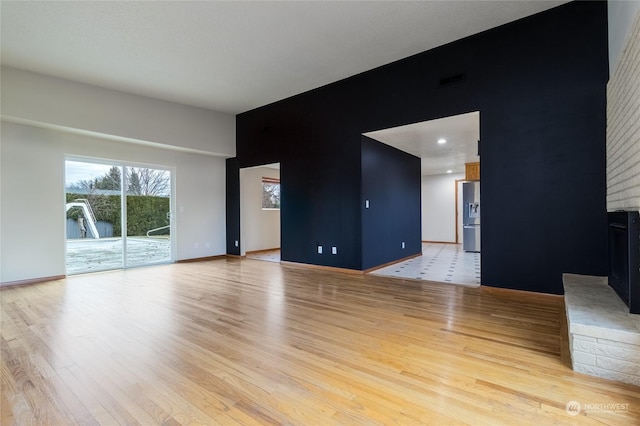 empty room featuring a fireplace and light hardwood / wood-style floors