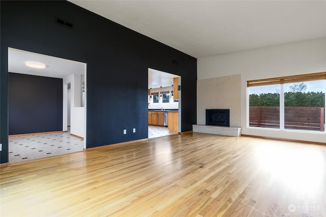 unfurnished living room with a fireplace and light hardwood / wood-style floors