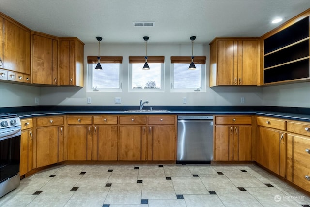 kitchen featuring decorative light fixtures, stainless steel appliances, a textured ceiling, and sink