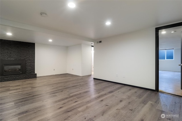 unfurnished living room with hardwood / wood-style floors and a fireplace