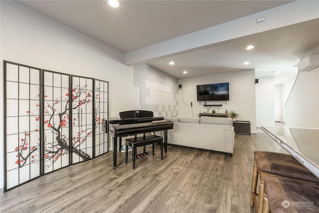 living room featuring a wall mounted AC, hardwood / wood-style floors, and beamed ceiling