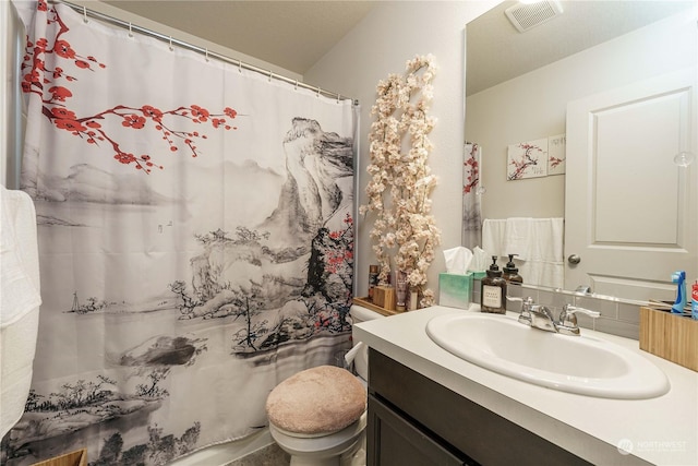 bathroom featuring toilet, vanity, and a shower with shower curtain