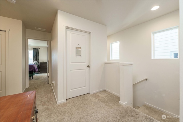 hall with light colored carpet and plenty of natural light