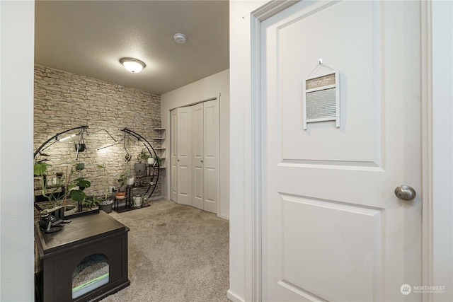 corridor featuring light carpet and a textured ceiling