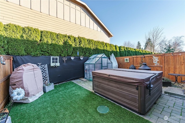 view of yard with an outbuilding, a hot tub, and a patio