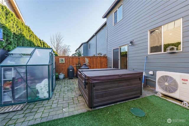 view of patio with ac unit, a hot tub, and an outdoor structure