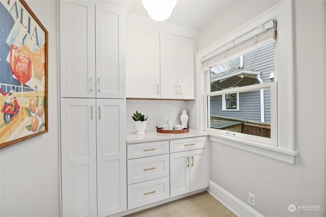 kitchen featuring white cabinetry, light tile patterned flooring, and decorative backsplash