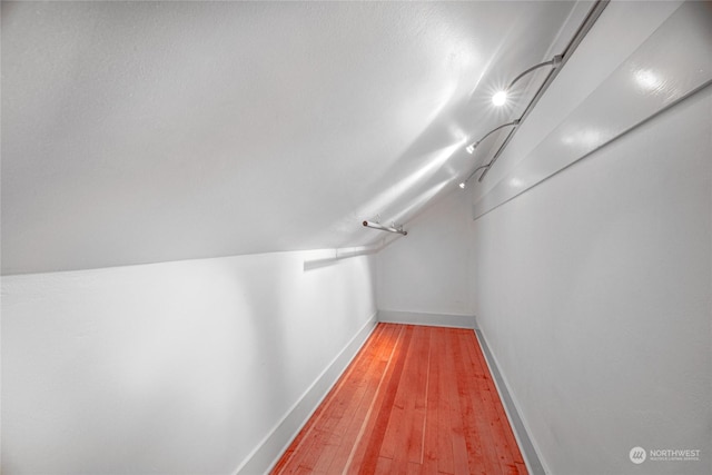 walk in closet featuring hardwood / wood-style floors and vaulted ceiling