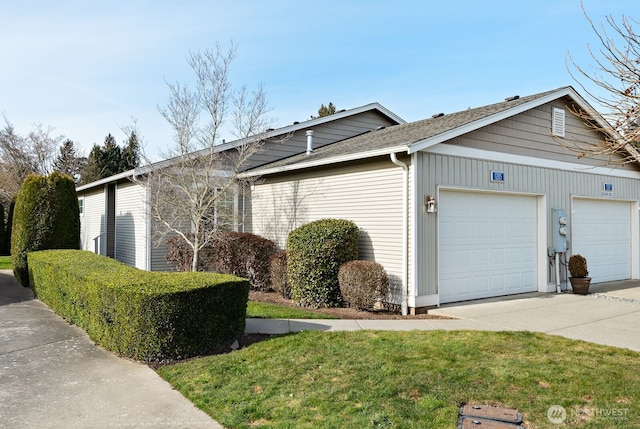 view of side of home featuring driveway, a shingled roof, and a garage