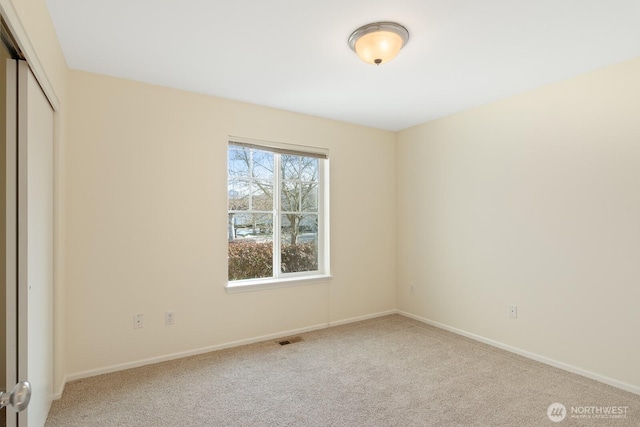 unfurnished bedroom with baseboards, visible vents, light colored carpet, and a closet