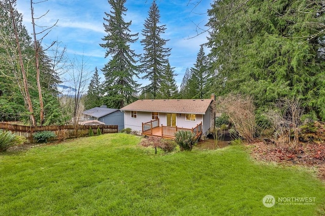 rear view of house featuring a deck and a lawn