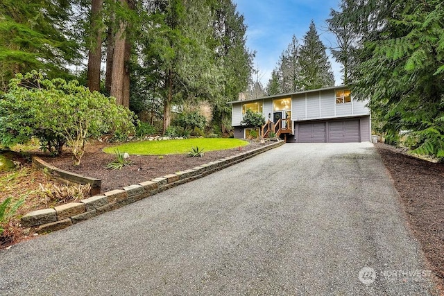 raised ranch featuring a front yard and a garage