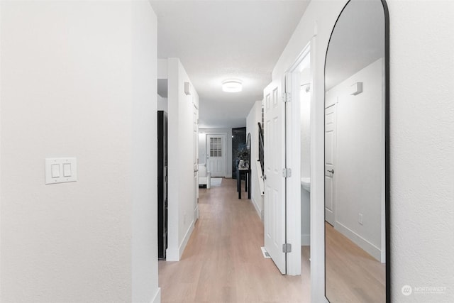 hallway with light hardwood / wood-style floors