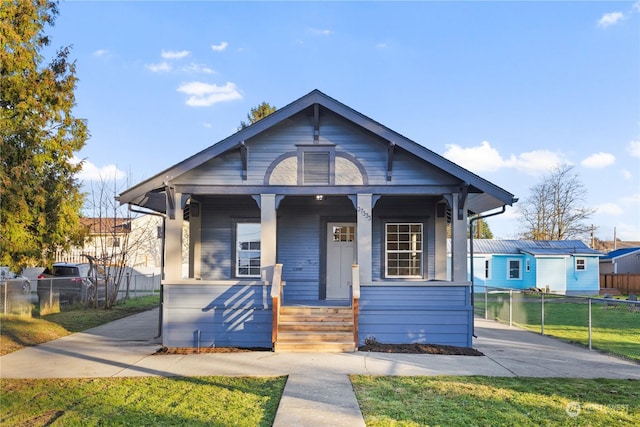 bungalow-style home featuring a front yard and covered porch