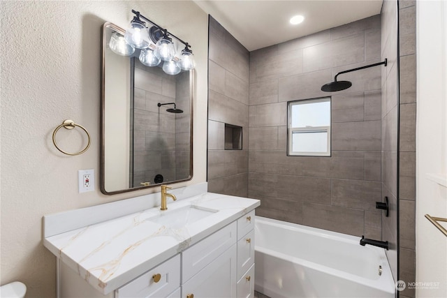 bathroom featuring vanity and tiled shower / bath