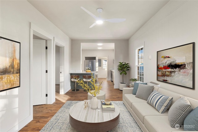 living room featuring ceiling fan and hardwood / wood-style floors