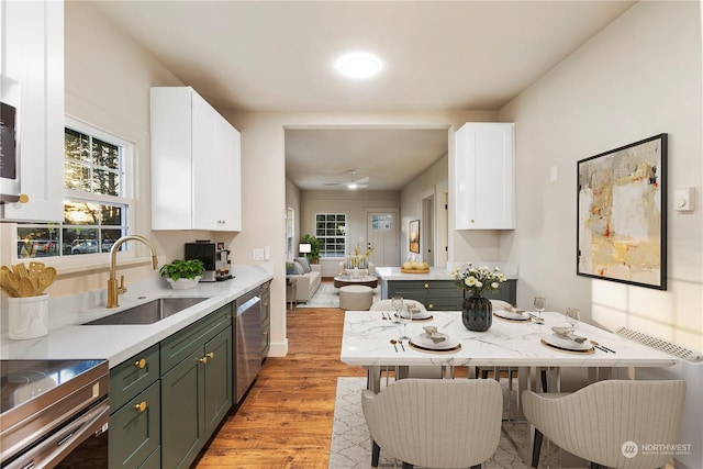 kitchen featuring white cabinets, dishwasher, green cabinetry, and sink