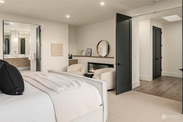 carpeted bedroom featuring ensuite bath