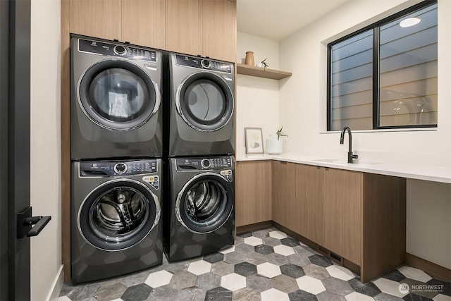 clothes washing area with stacked washer / drying machine and sink