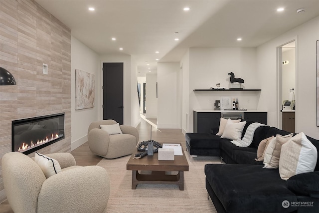 living room with light hardwood / wood-style floors and a tile fireplace