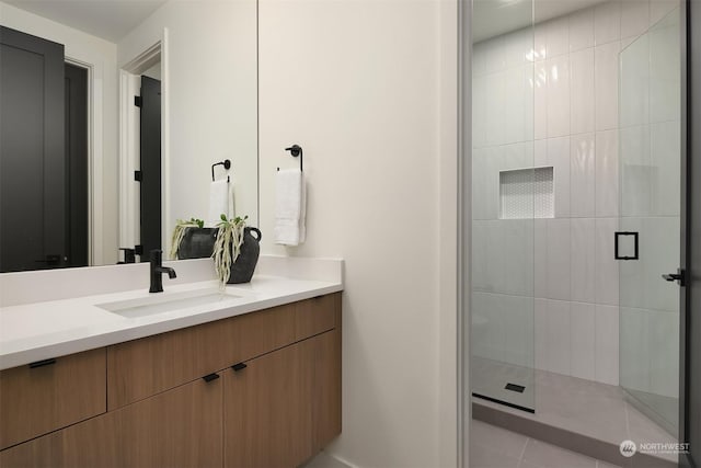 bathroom featuring tile patterned flooring, vanity, and a shower with shower door