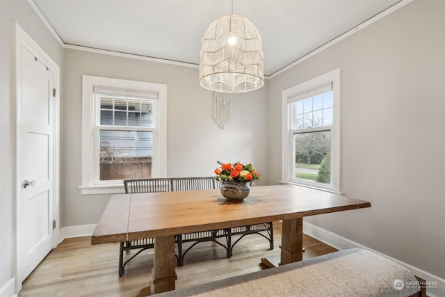 dining space featuring light hardwood / wood-style flooring, an inviting chandelier, and crown molding