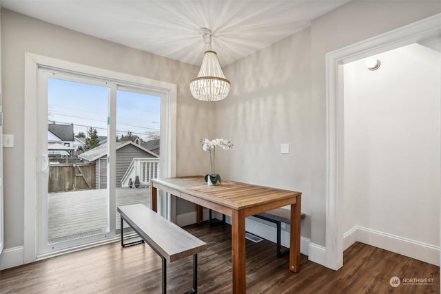 dining space featuring dark hardwood / wood-style flooring and an inviting chandelier