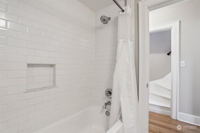 bathroom with shower / tub combo and hardwood / wood-style flooring