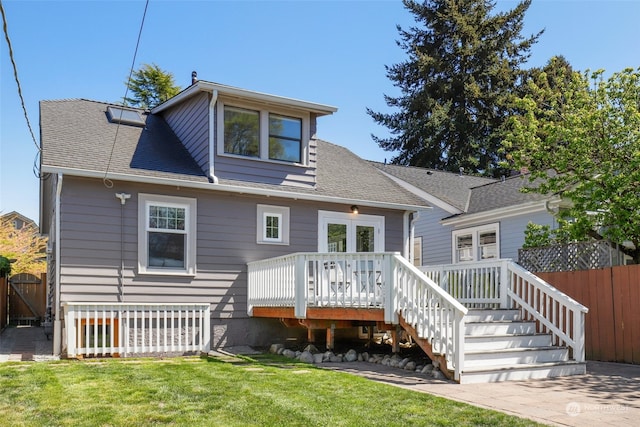 rear view of house featuring a yard and a deck