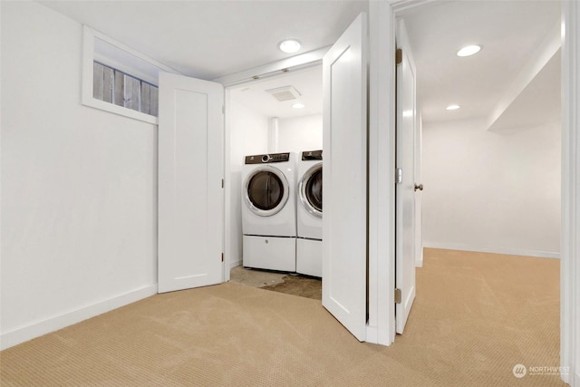 washroom featuring washer and clothes dryer and light carpet