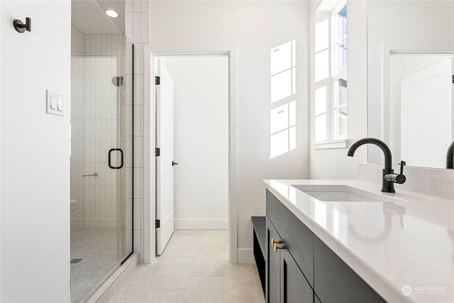 bathroom with an enclosed shower, vanity, and tile patterned floors