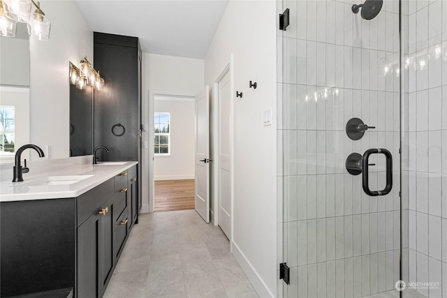 bathroom featuring tile patterned flooring, a shower with shower door, plenty of natural light, and vanity