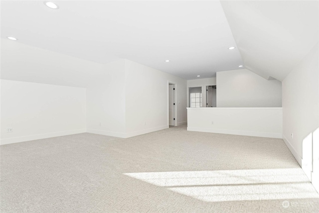 bonus room with light carpet and lofted ceiling