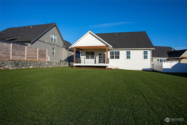 rear view of house featuring a yard