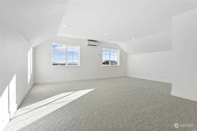 bonus room featuring light colored carpet, a wall unit AC, and vaulted ceiling