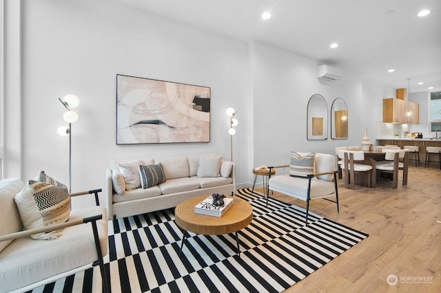 living room featuring light hardwood / wood-style flooring and a wall mounted air conditioner