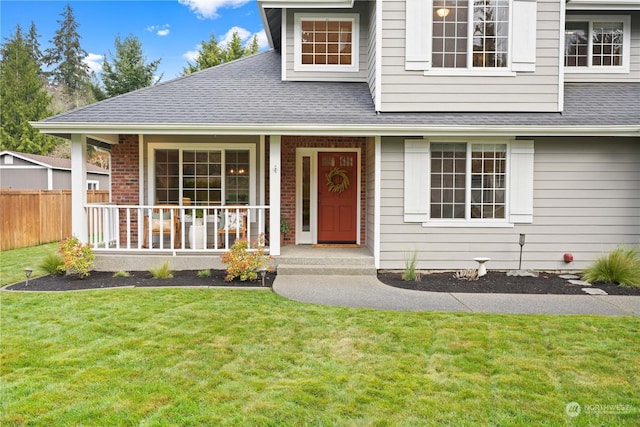 view of front of property featuring covered porch and a front lawn