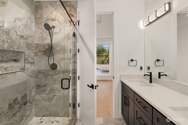 bathroom featuring vanity and a shower with door