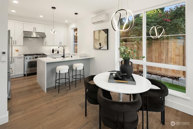 dining room with dark hardwood / wood-style floors, sink, and a wall mounted air conditioner