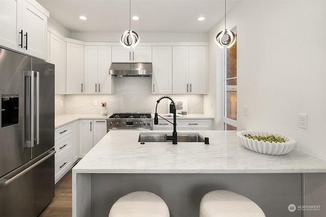 kitchen with stove, decorative light fixtures, a breakfast bar, and high quality fridge