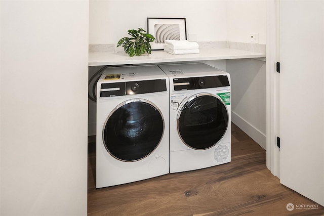 clothes washing area with washer and clothes dryer and dark hardwood / wood-style flooring