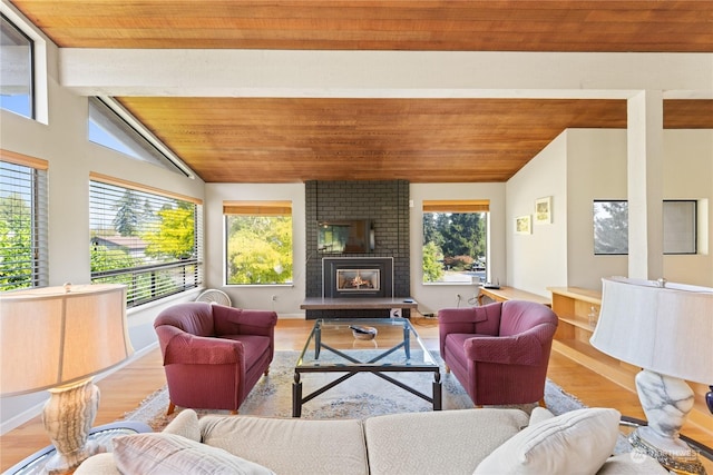 living room with hardwood / wood-style floors, lofted ceiling with beams, and a brick fireplace