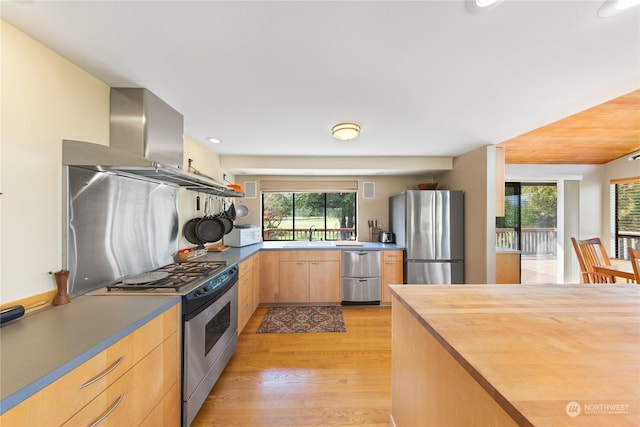 kitchen featuring light brown cabinets, light hardwood / wood-style floors, island range hood, butcher block counters, and stainless steel appliances