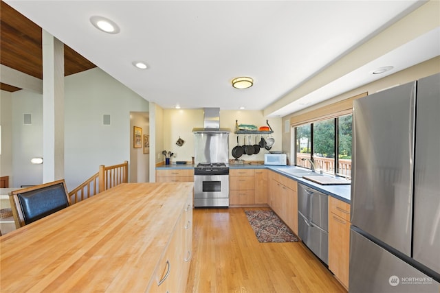 kitchen with sink, wall chimney exhaust hood, stainless steel appliances, light brown cabinetry, and light wood-type flooring