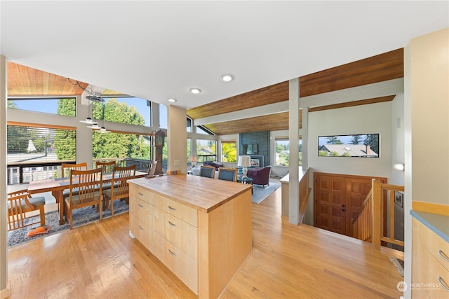 kitchen featuring butcher block countertops, a wealth of natural light, light brown cabinetry, and a kitchen island