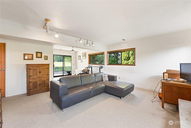 living room with light carpet, rail lighting, and a healthy amount of sunlight