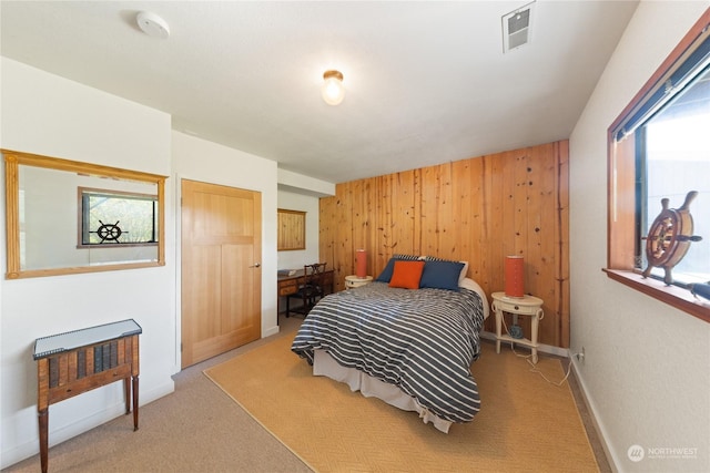 bedroom with wood walls and carpet floors